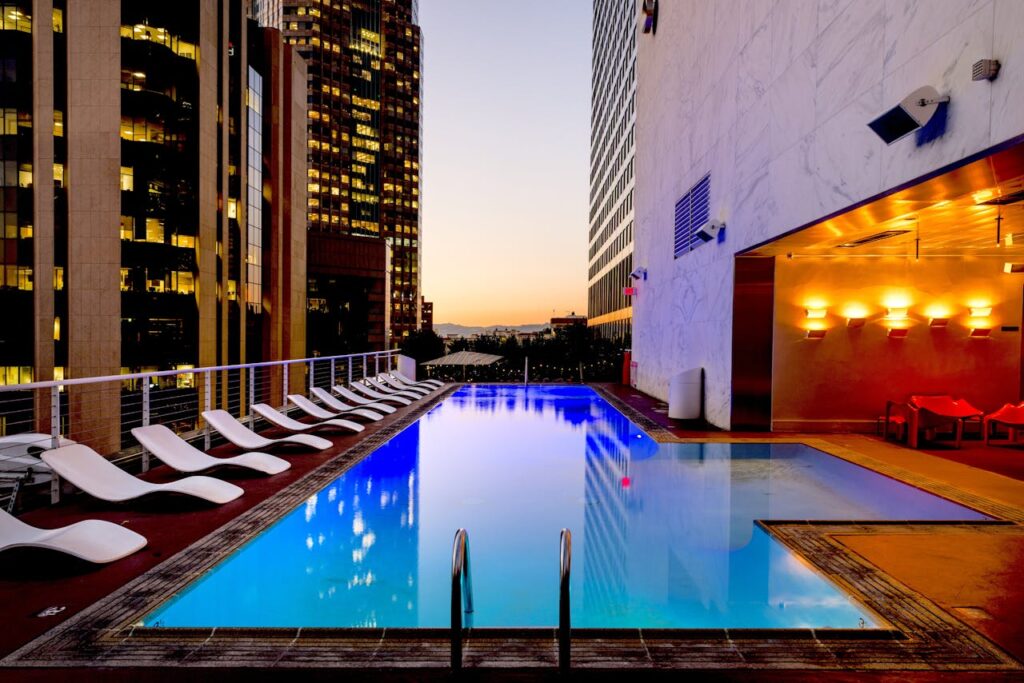 Elegant rooftop pool with cityscape backdrop at sunset, reflecting urban luxury.